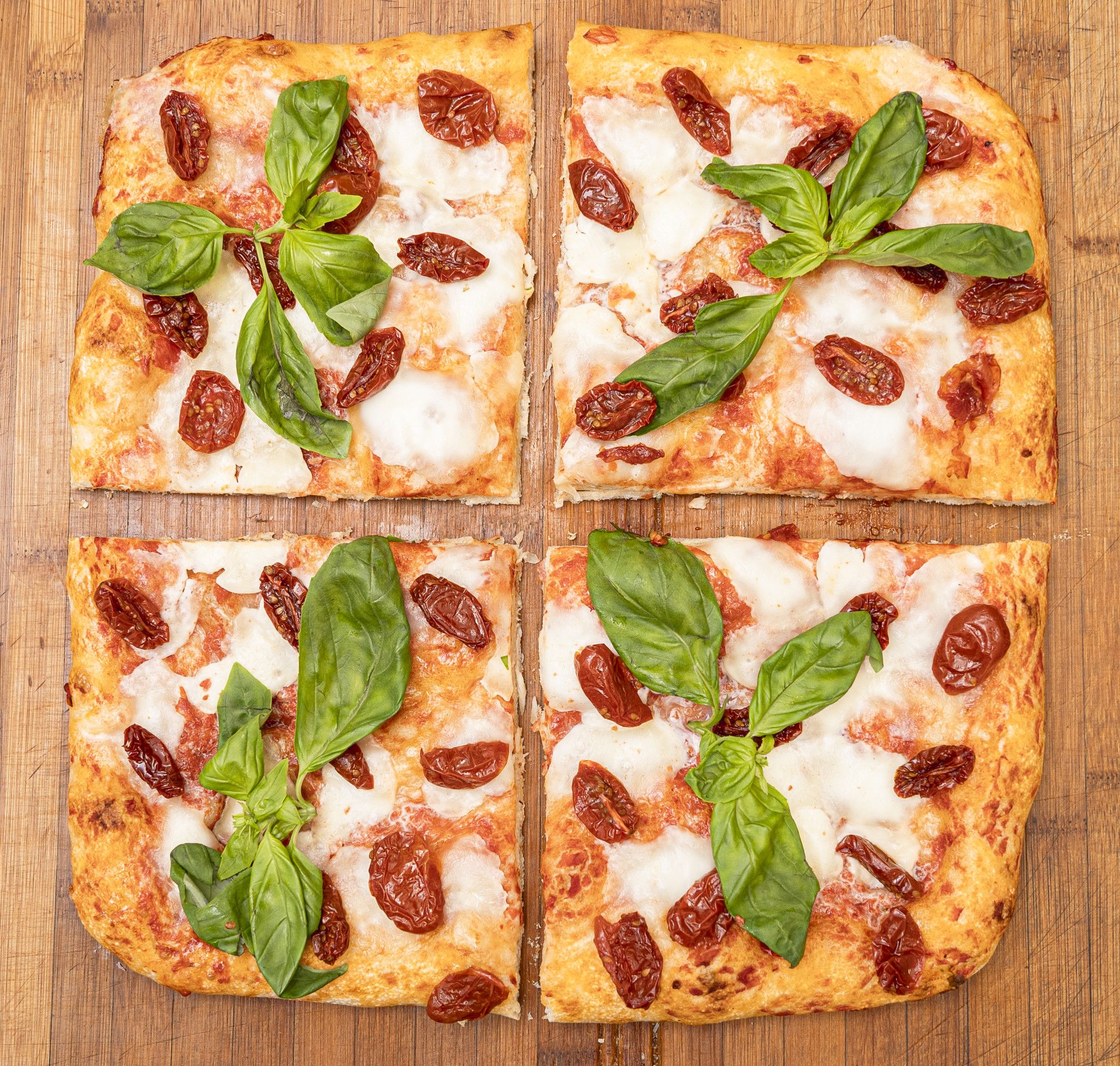 TRANCIO DI PIZZA CON MOZZARELLA DI BUFALA, POMODORINI, BASILICO E EVO
