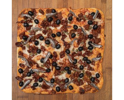 TRANCIO DI PIZZA CON POMODORO, MOZZARELLA, POMODORI SECCHI, ACCIUGHE, CAPPERI E OLIVE