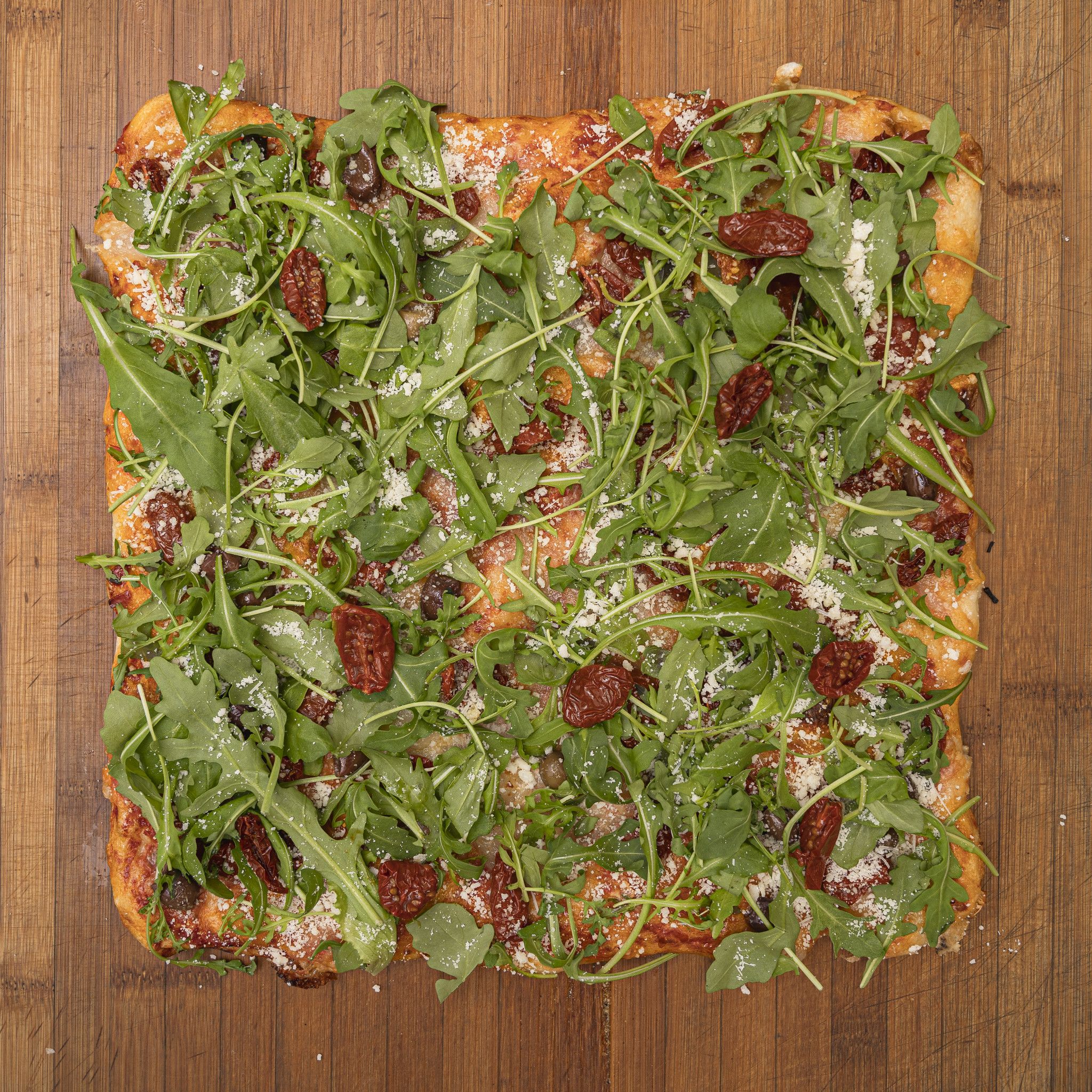 TRANCIO DI PIZZA CON POMODORO, MOZZARELLA DI BUFALA, OLIVE DI TAGGIA, RUCOLA E GRANA