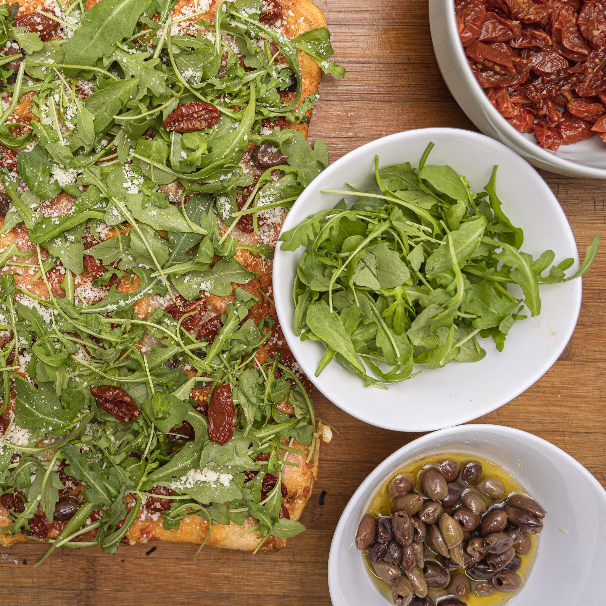 TRANCIO DI PIZZA CON POMODORO, MOZZARELLA DI BUFALA, OLIVE DI TAGGIA, RUCOLA E GRANA