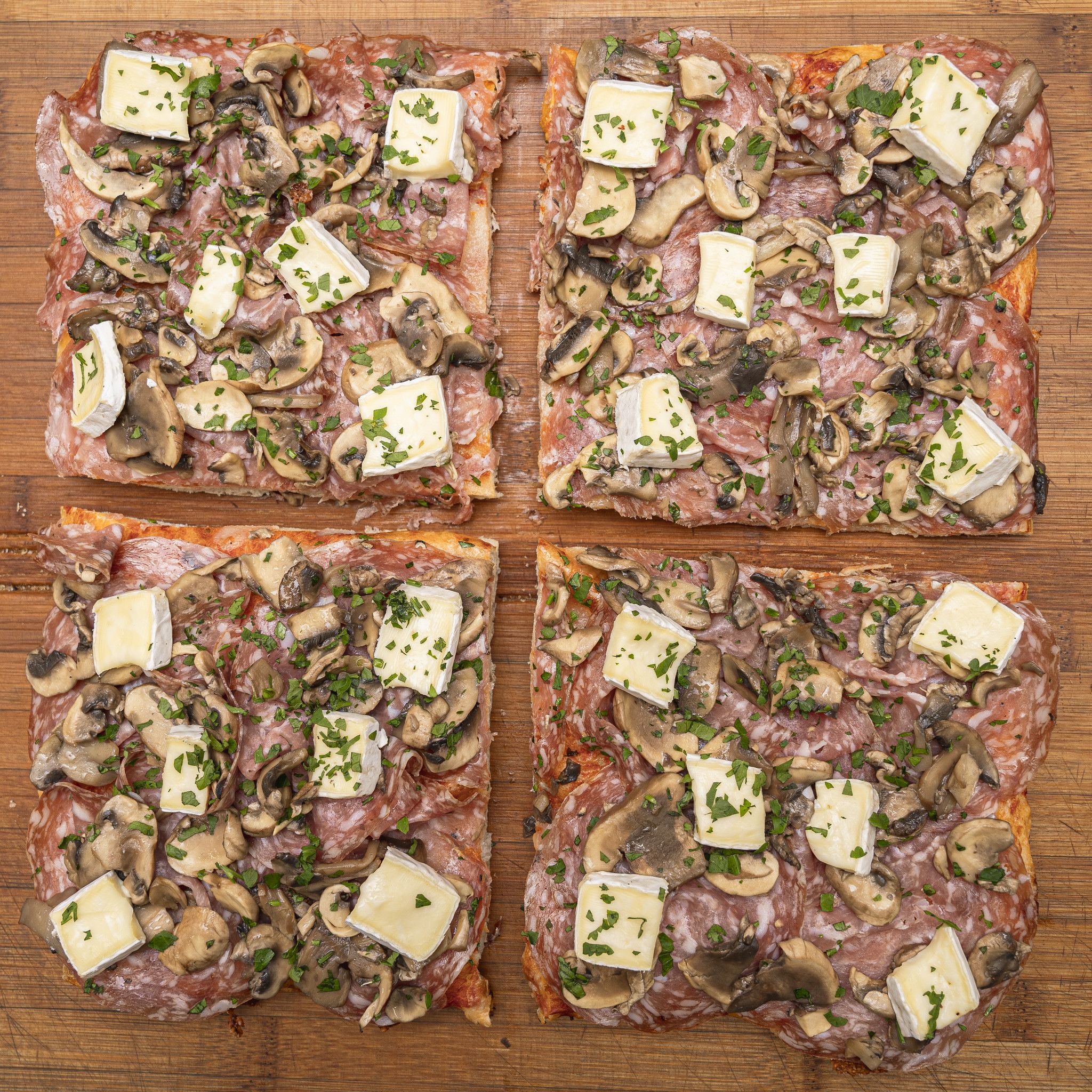 TRANCIO DI PIZZA CON POMODORO, MOZZARELLA, SOPRESSA, FUNGHI, BRIE E PREZZEMOLO