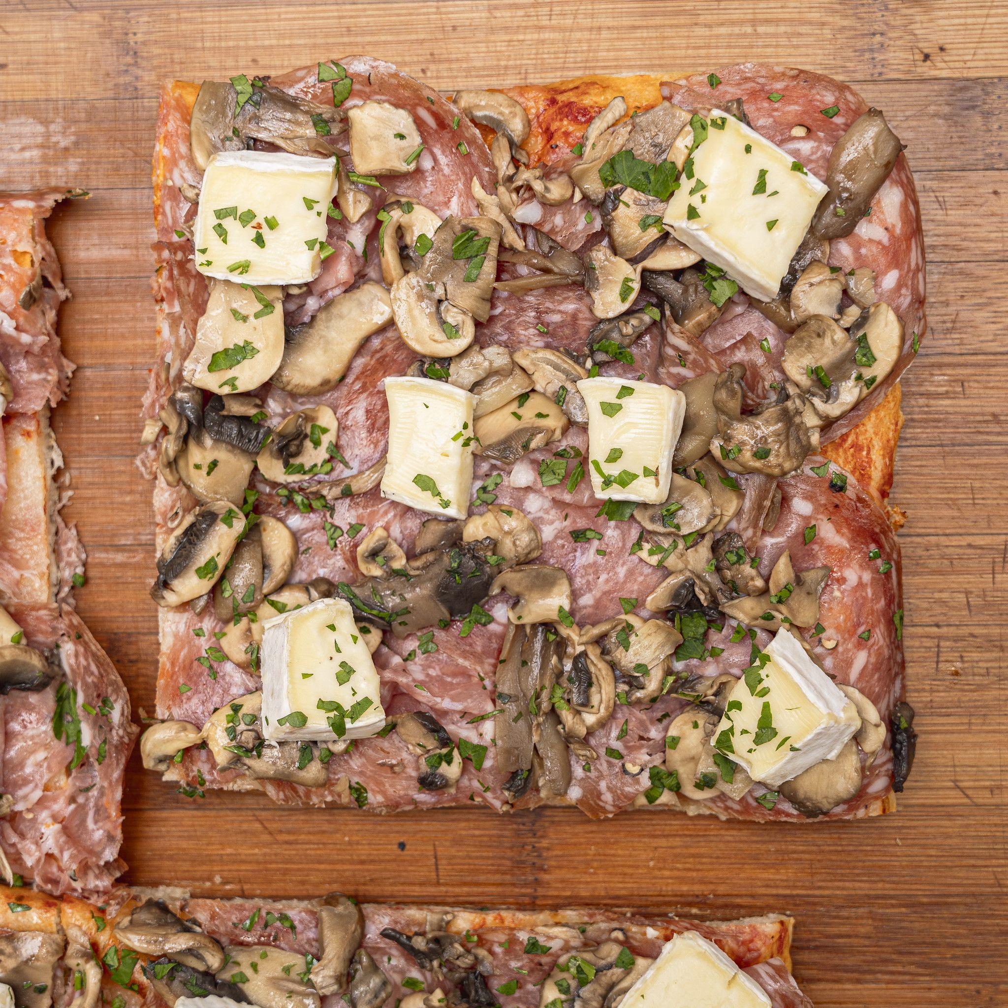 TRANCIO DI PIZZA CON POMODORO, MOZZARELLA, SOPRESSA, FUNGHI, BRIE E PREZZEMOLO