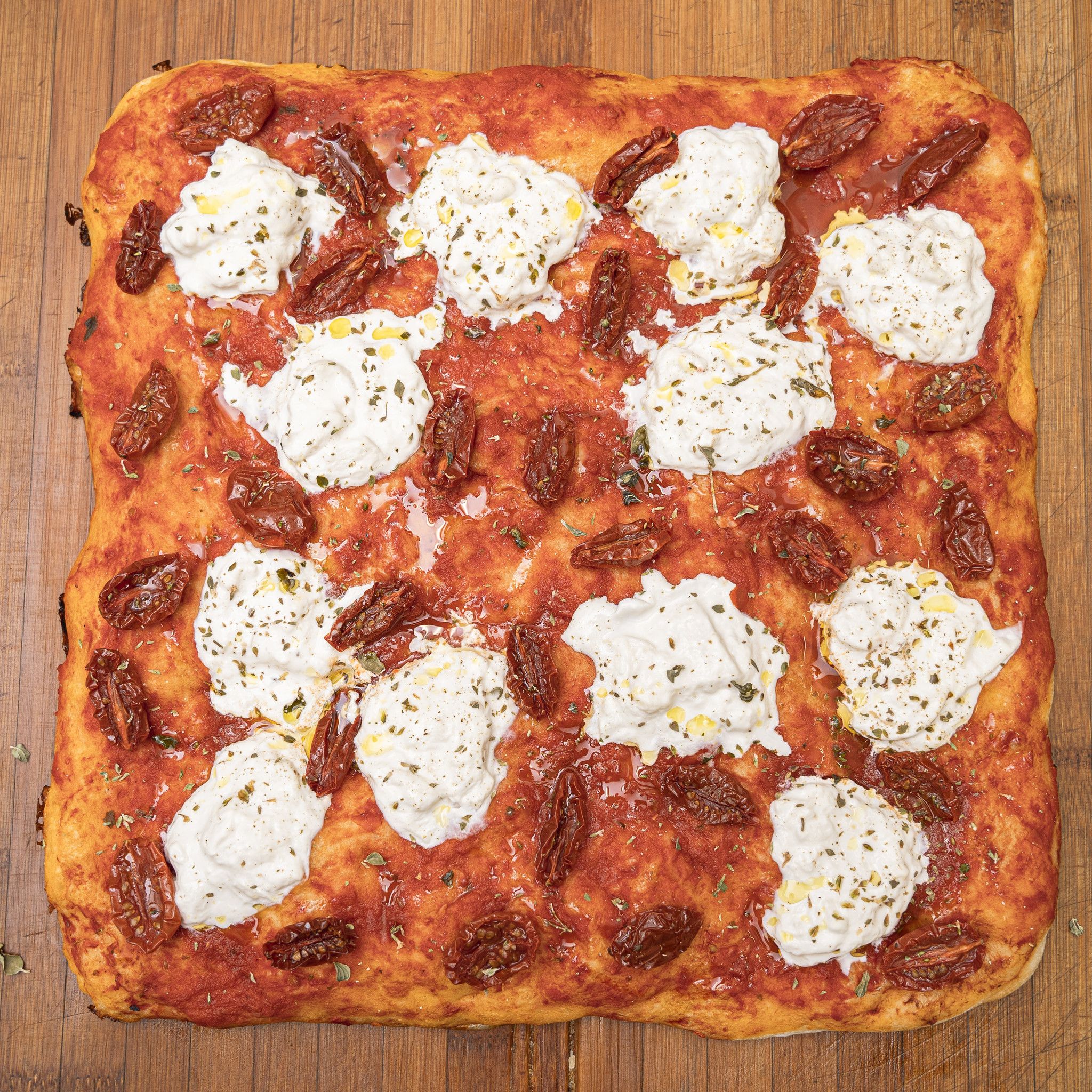 TRANCIO DI PIZZA CON POMODORO STRACCIATELLA, POMODORINI, ORIGANO E EVO