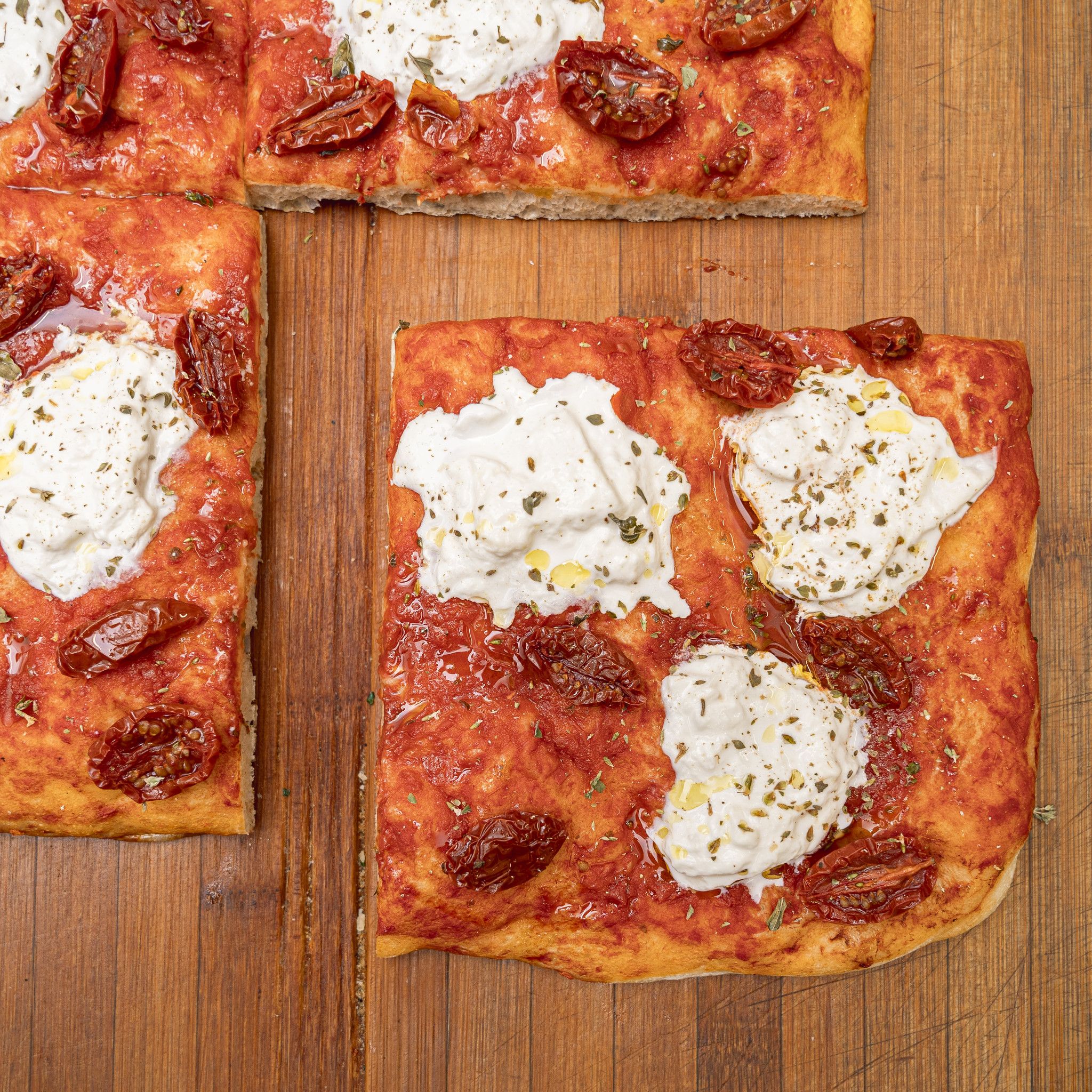TRANCIO DI PIZZA CON POMODORO STRACCIATELLA, POMODORINI, ORIGANO E EVO